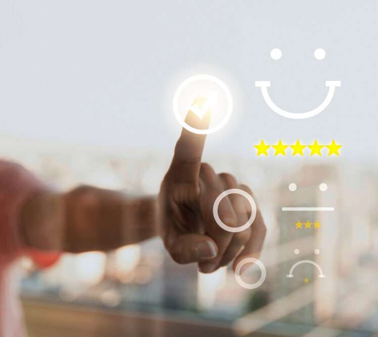 Imagen luminosa con fondo difuminado de ventana con edificios, primer plano de mano seleccionando una opción de satisfacción en una interfaz digital con iconos de caritas (sonriente, neutra, triste) y estrellas de valoración amarillas. Concepto de experiencia del cliente, feedback, satisfacción y calidad del servicio