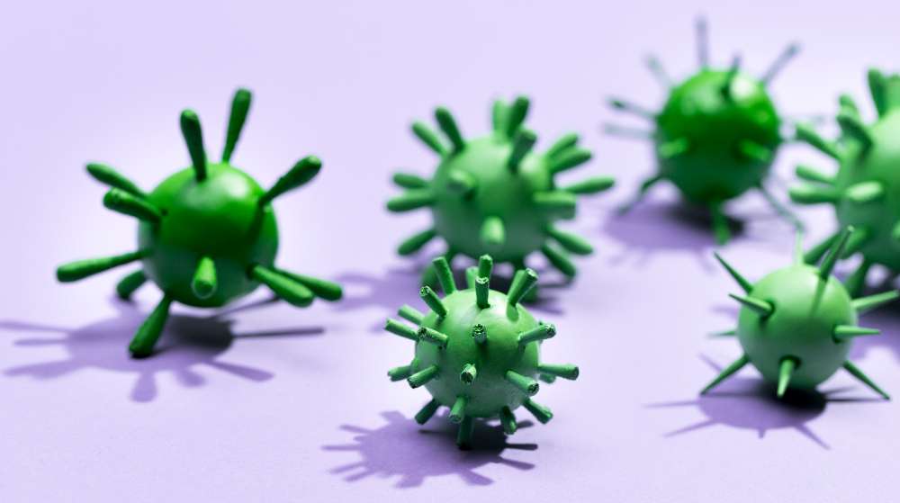 Representación 3D de bacterias y virus en color verde sobre fondo de gris violaceo