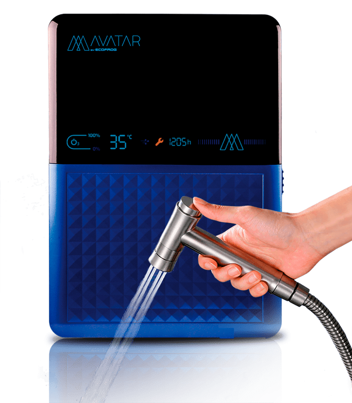 Máquina AVATAR by ECOFROG, mitad azul con un motivo en relieve de pirámides pequeñas y mitad negra. Esta parte oscura corresponde a una pantalla LED que está encendida donde se ven diversos indicadores y acciones activos, con su reflejo proyectado en la base de la imagen y un grifo sujetado por una mano femenina expulsando agua ozonizada.